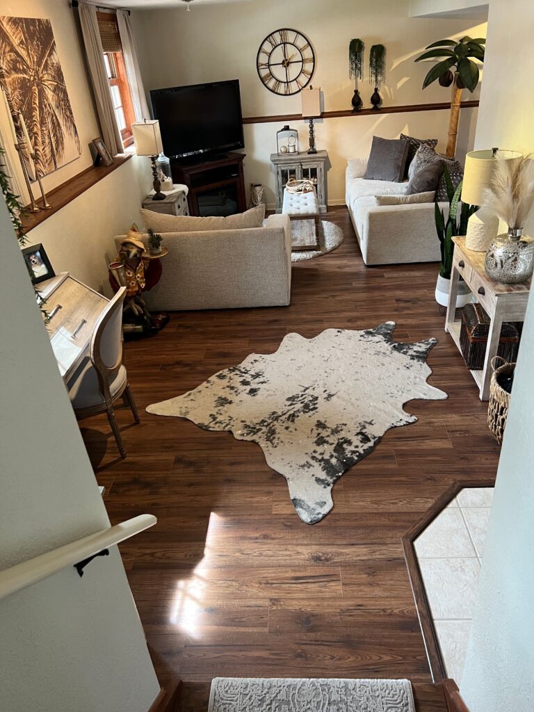 Warm walnut-look flooring through a furnished living room