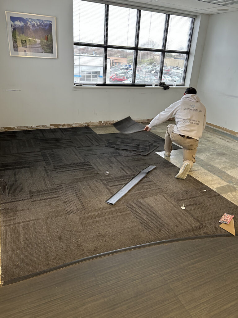 Carpet tile installation underway in a commercial room