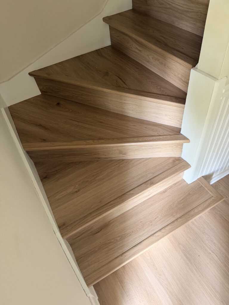 Finished winding staircase with coordinated wood-look flooring
