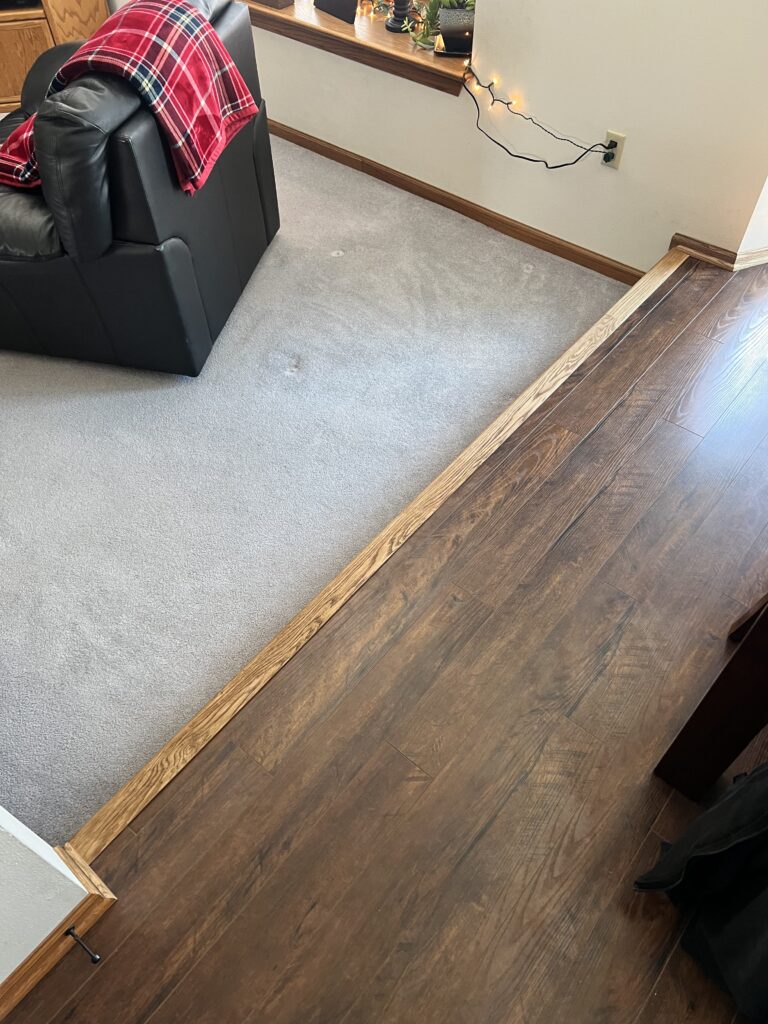 Detailed flooring transition work between adjoining surfaces