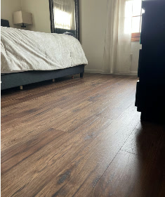Bedroom with brown wood-look plank flooring